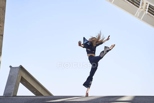 Donna con le braccia tese che salta mentre balla — Foto stock