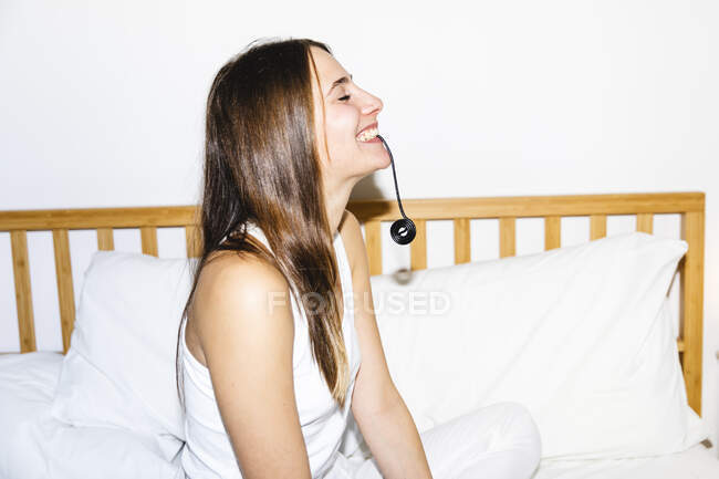 Happy young woman eating licorice candy in bedroom — Stock Photo
