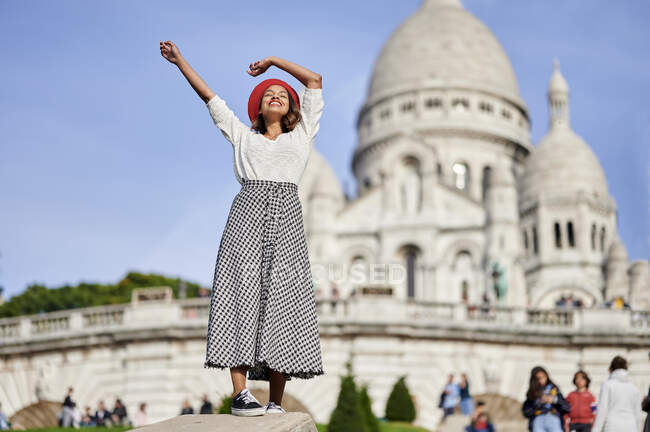 Turista femminile con le mani alzate a Basilique Du Sacre Coeur, Montmartre a Parigi, Francia — Foto stock