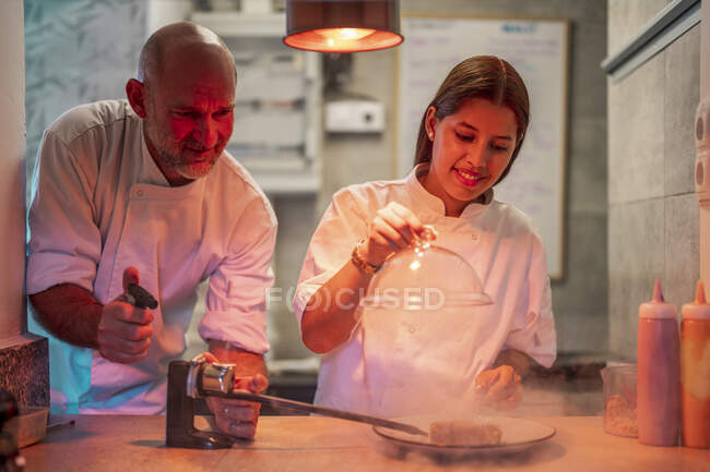 Chefs masculins et féminins fumant dans la cuisine — Photo de stock