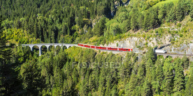 Switzerland, Graubunden Canton, Train crossing Landwasser Viaduct in summer — Stock Photo