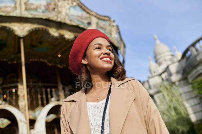 Lächelnde Frau mit Karussell und Basilique Du Sacre Coeur im Hintergrund auf dem Montmartre, Paris, Frankreich — Stockfoto