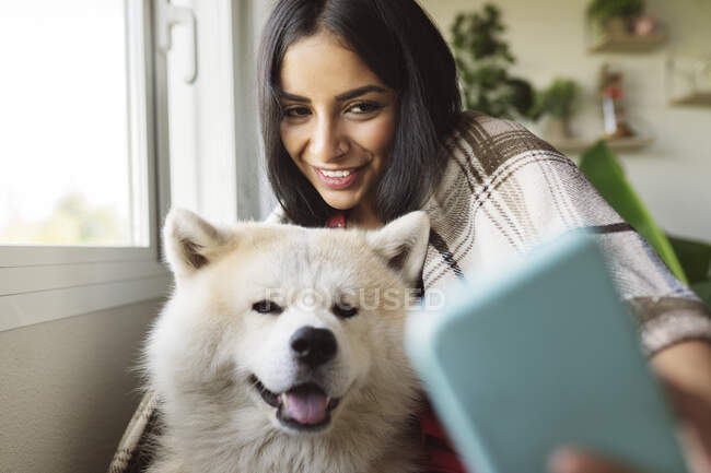 directorio Dificil Sin sentido Mujer sonriente tomando selfie con perro en casa — una persona, Pedigrí  perro - Stock Photo | #527914278