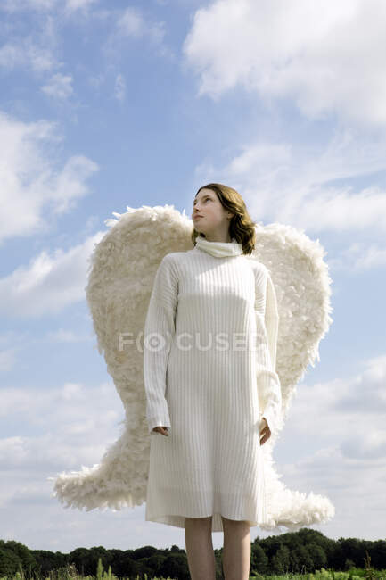 Ragazza adolescente che indossa ali bianche contemplando nella giornata di sole — Foto stock