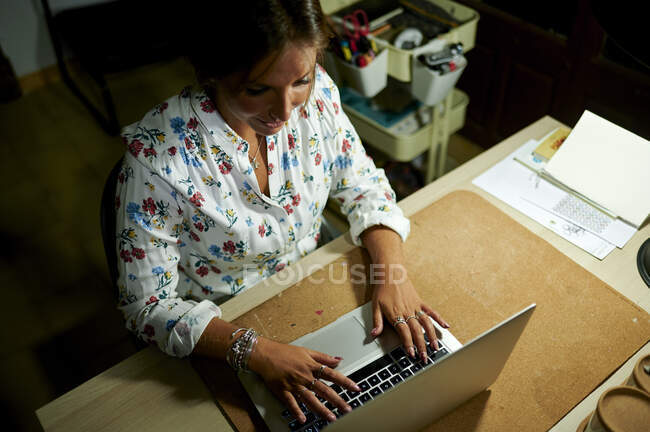 Jovem mulher profissional digitando no laptop na mesa no escritório — Fotografia de Stock