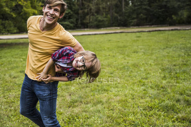 Щасливий чоловік грає з хлопчиком у парку. — стокове фото