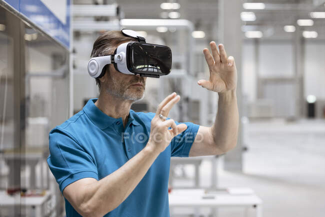 Homme mature geste professionnel tout en utilisant le simulateur de réalité virtuelle dans l'usine — Photo de stock