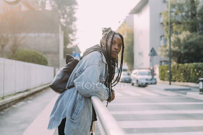 Frau mit Rucksack stützt sich auf Geländer — Stockfoto