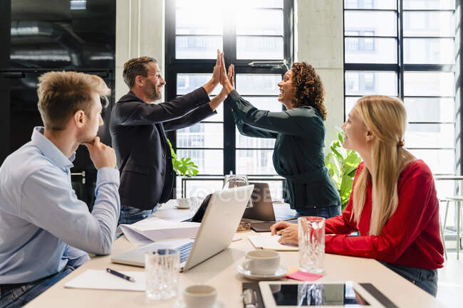 Coworkers cheering in meeting at office — Stock Photo