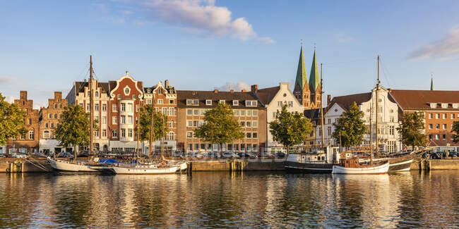 Deutschland, Schleswig-Holstein, Lübeck, Blick auf Segelschiffe am Trave-Kanal mit historischen Stadthäusern im Hintergrund — Stockfoto