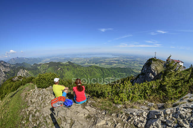 Coppia guardando la vista mentre seduto sulla montagna Hochfelln durante le vacanze — Foto stock