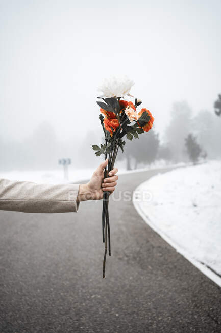 Mann mit Blumen auf Straße im Winter — Stockfoto