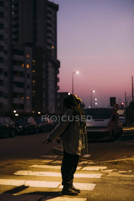 Mujer joven con los ojos cerrados en la carretera por la noche - foto de stock