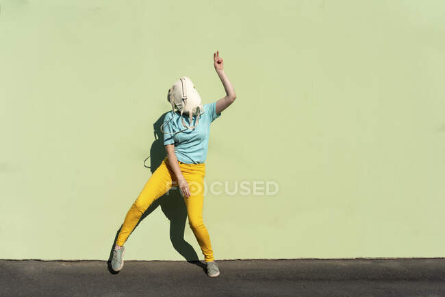 Mulher brincalhão com mochila na cara dançando durante o dia ensolarado — Fotografia de Stock