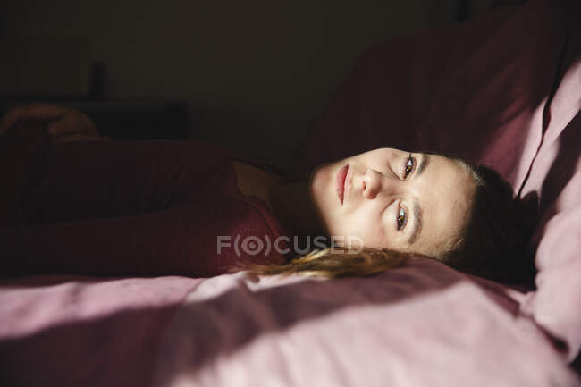Femme émotionnellement stressée couchée sur le lit à la maison — Photo de stock