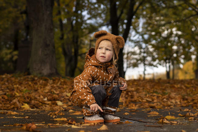 Bambino con bastone che gioca a pozzanghera — Foto stock