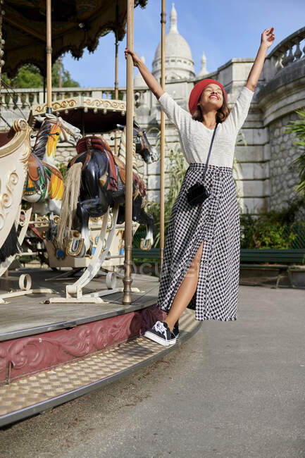 Unbekümmerte Frau am Karussell mit Basilique Du Sacre Coeur im Hintergrund am Montmartre, Paris, Frankreich — Stockfoto
