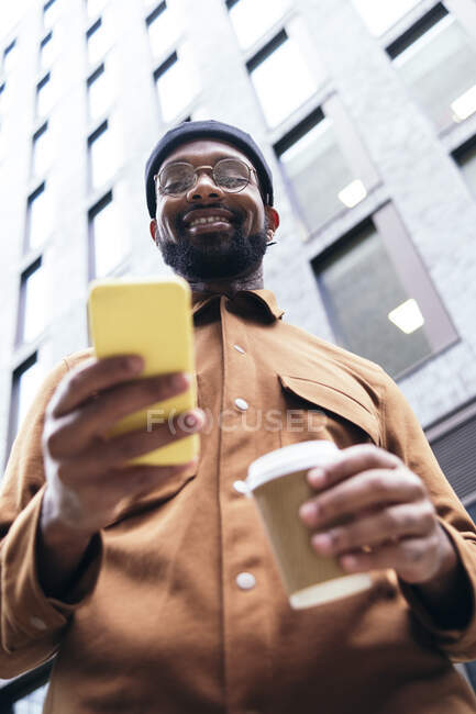 Uomo sorridente utilizzando smart phone — Foto stock