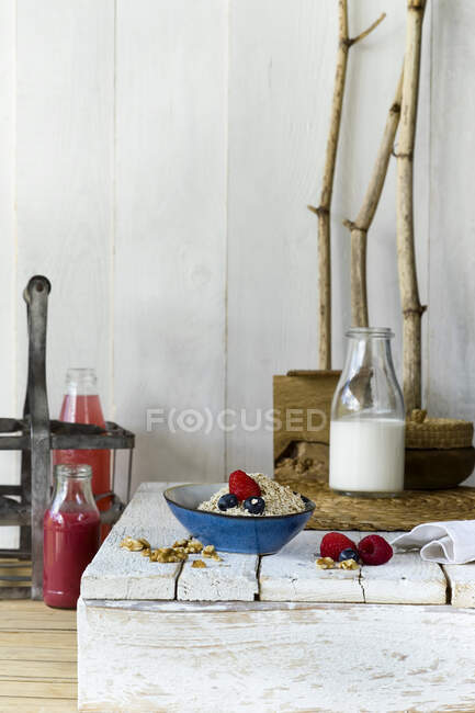 Bol de muesli et bouteille de lait debout sur une surface en bois — Photo de stock
