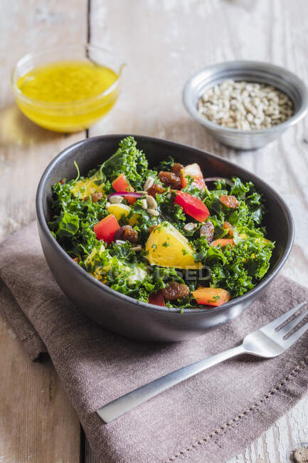 Bowl of kale salad with bell peppers and orange — Stock Photo