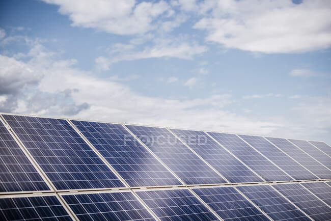 Облака над рядами панелей солнечных электростанций — стоковое фото