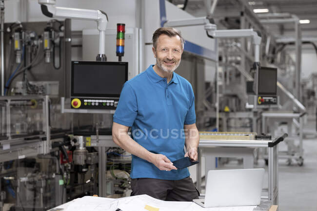 Hombre sosteniendo célula solar en fábrica - foto de stock