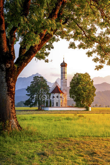 Germany, Bavaria, Schwangau, Meadow in front of St. Coloman's Church at dusk — Stock Photo