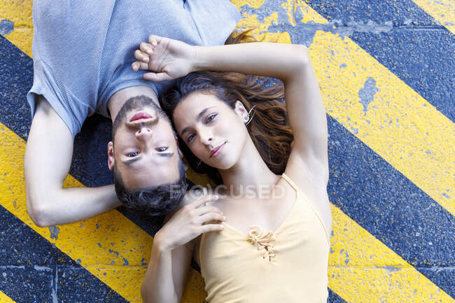 Giovane coppia sdraiata insieme sul sentiero — Foto stock