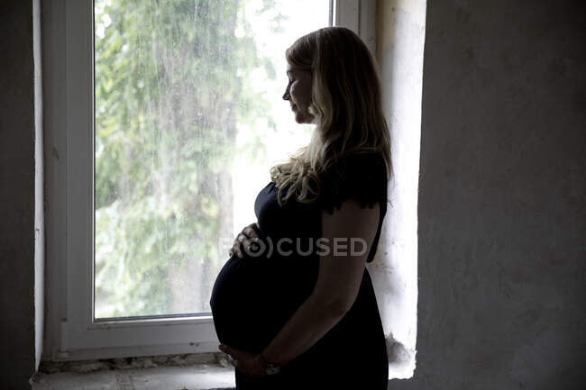 Schwangere mit geschlossenen Augen am Fenster — Stockfoto