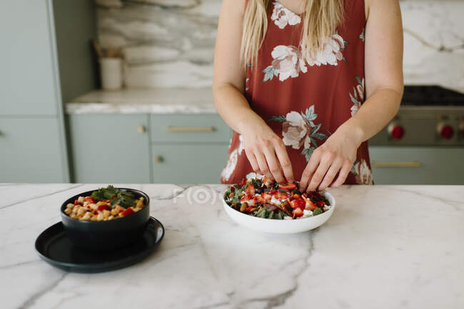 Piatto di guarnitura nutrizionista femminile con fragola tritata al bancone della cucina — Foto stock