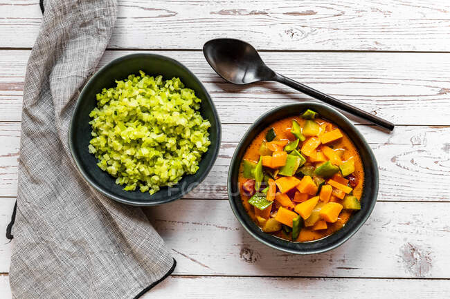Studio shot of bowl of ready-to-eat low carb curry and chopped broccoli — Stock Photo