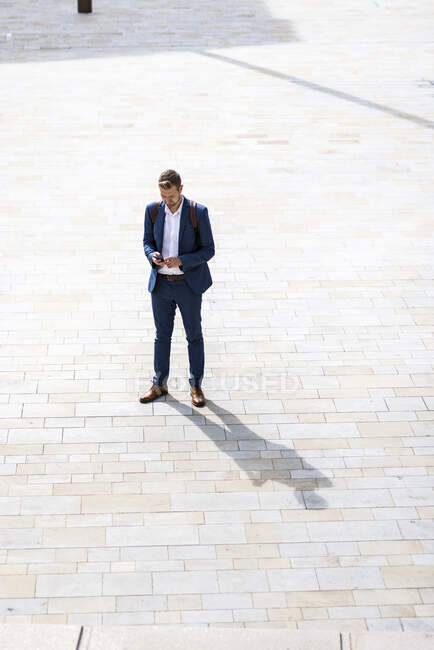 Бізнесмен користується мобільним телефоном у сонячний день. — стокове фото