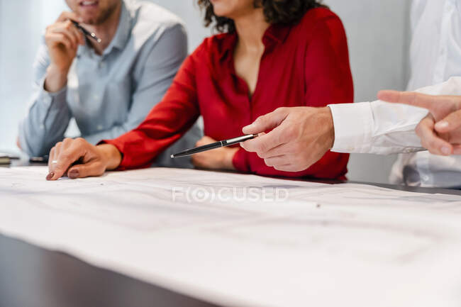 Бізнесмен вказує перо на план зустрічі в офісі — стокове фото