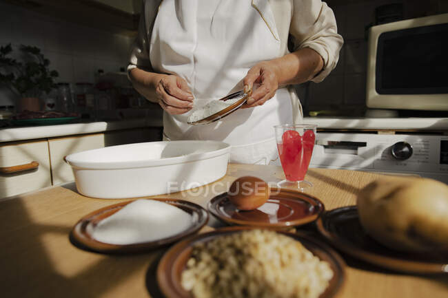 Woman with ingredients preparing panellets in kitchen — Stock Photo
