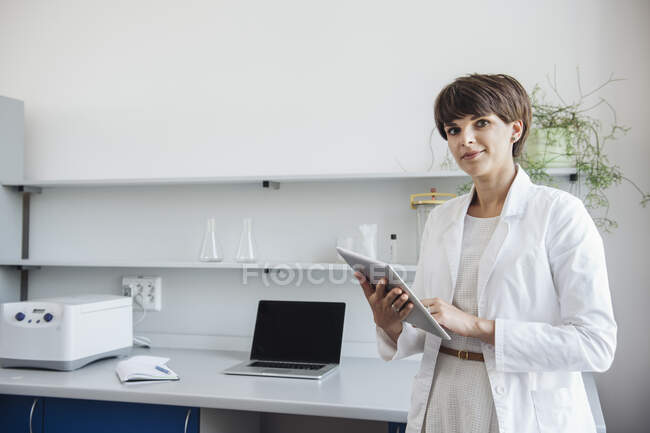 Scientist holding digital PC in laboratory — Stock Photo