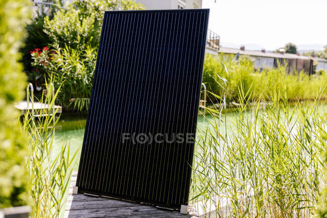 Panel fotovoltaico de pie frente a la piscina exterior - foto de stock