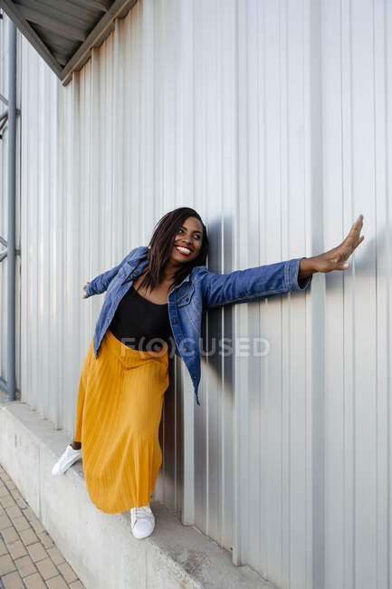 Donna allungamento mano in piedi da parete — Foto stock
