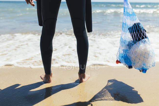 Волонтер держит сумку с мешком на пляже — стоковое фото