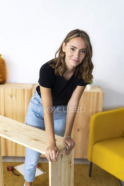 Junge Frau baut Möbel zu Hause zusammen — Stockfoto