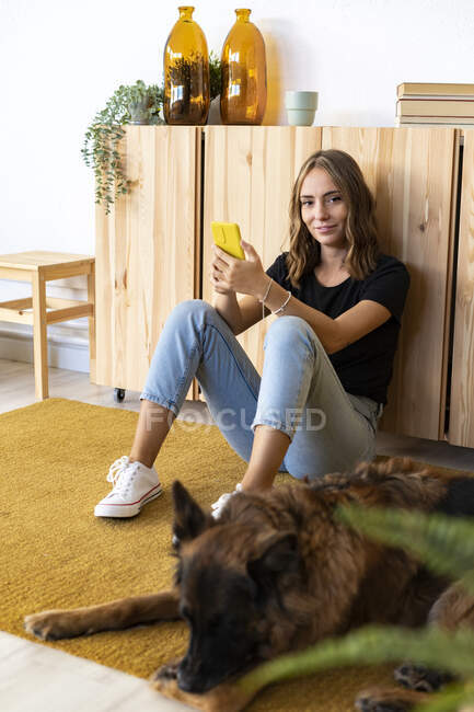 Donna sorridente da cane a casa — Foto stock