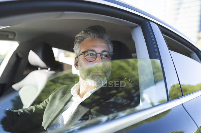 Businessman driving car in city — Stock Photo