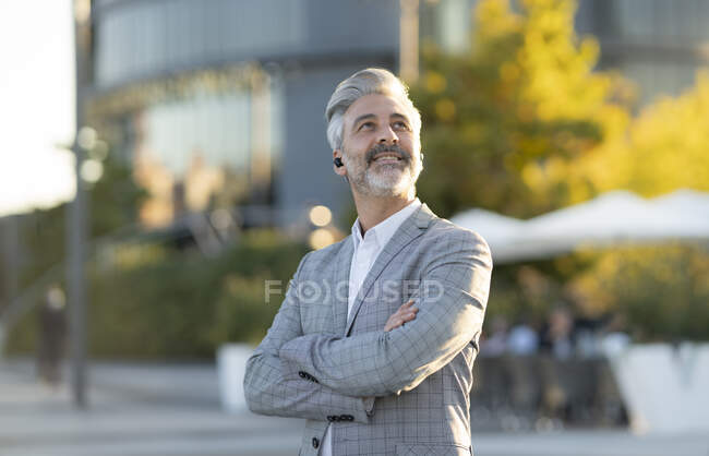 Gerente seguro mirando hacia arriba con los brazos cruzados - foto de stock