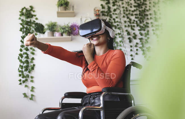 Усміхнена жінка з віртуальною реальністю жестикулює вдома. — стокове фото
