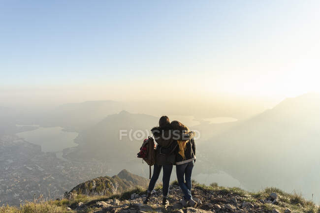 Mulher abraçando amigo no pico da montanha em Lecco, Itália — Fotografia de Stock