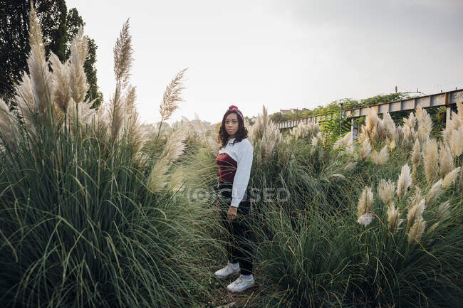 Woman with headband standing amidst grass — Stock Photo