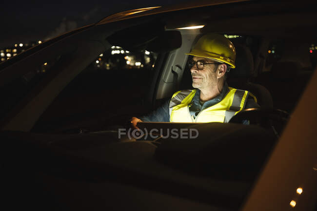 Thoughtful engineer with laptop in car at night — Stock Photo