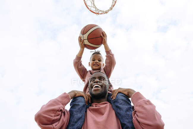 Allegro padre e figlio che giocano a basket al campo sportivo — Foto stock