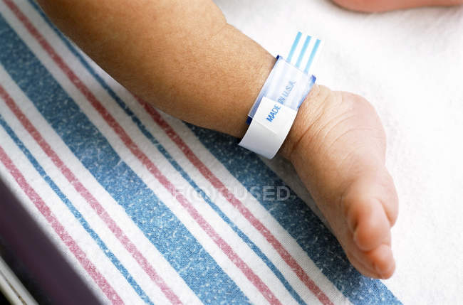 Close Up Of Hospital Identification Bracelet On Newborn Boy Ankle Close Up Of Hospital Identification Bracelet On Newborn Boy Ankle Stock Photo