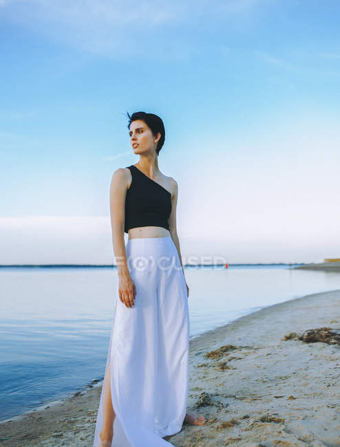 Woman posing on pier in dress — Stock Photo