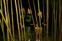 Women posing with bamboo branches — Stock Photo
